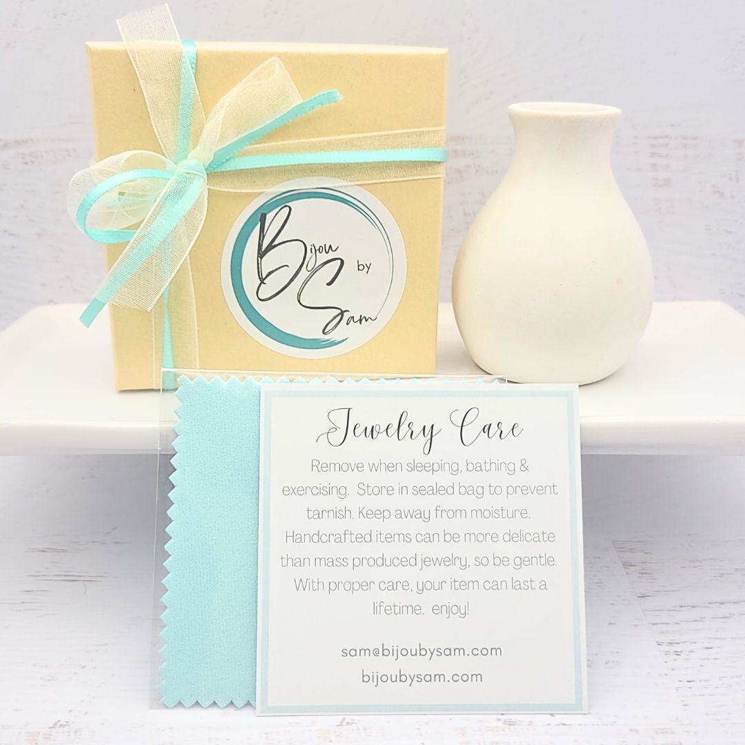 Small gold circle earrings from Bijou by SAM's Aiden collection displayed in packaging.