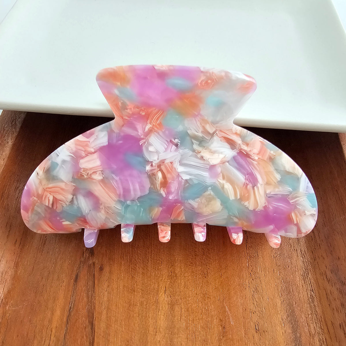 Spiffy & Splendid Candace Hair Claw in Afterglow displayed holding and securing hair, showcasing its stylish design and vibrant color.